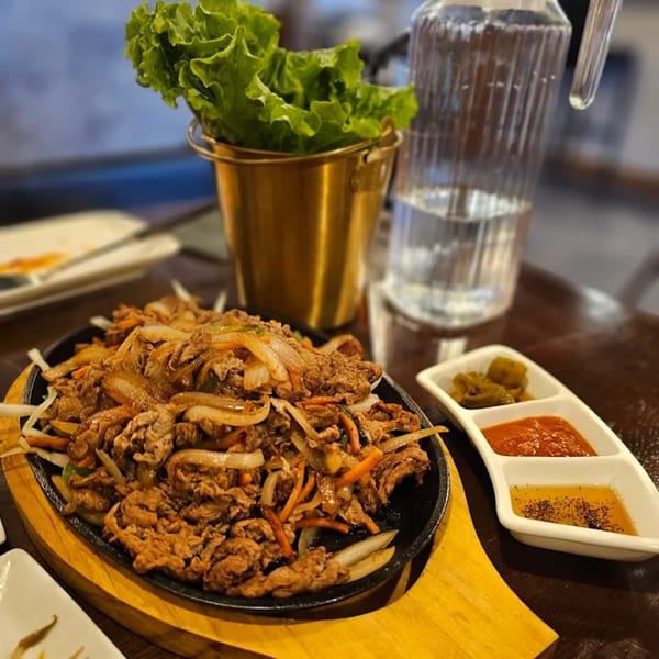 Sizzling Korean bulgogi with onions and carrots, served with lettuce wraps and dipping sauces.
